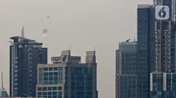Bendera Merah Putih raksasa dikibarkan menggunakan helikopter TNI AU mengelilingi Jakarta, Jumat (13/8/2021). Pengibaran bendera yang dilakukan TNI AU sebagai bentuk latihan untuk persiapan puncak peringatan HUT ke-76 RI pada tanggal 17 Agustus 2021 mendatang. (Liputan6.com/Herman Zakharia)