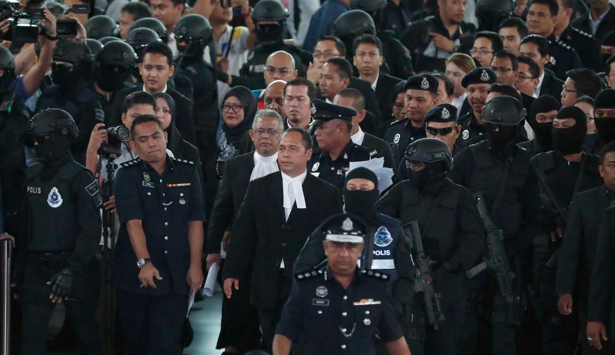 Hakim Datuk Azmi Ariffin  bersama jaksa dan pengacara tiba di Bandara Internasional Kuala Lumpur, Selasa (24/10). Hari ini, Siti Aisyah dan Doan Thi Huong melakukan reka ulang kejadian di tempat keduanya dituding meracuni Kim Jong-nam. (AP/Sadiq Asyraf)