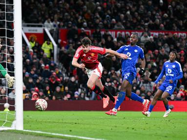 Pemain Manchester United, Harry Maguire, mencetak gol penentu kemenangan ke gawang Leicester City pada laga putaran keempat Piala FA di Stadion Old Trafford, Sabtu, (8/2/2025). (AFP/Oli Scarff)