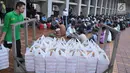 Petugas membagikan takjil jelang berbuka puasa pada hari kedua bulan Ramadan di Masjid Istiqlal, Jakarta, Minggu (28/5). Sebanyak 5000 kotak makanan dibagikan untuk berbuka pada gari Jumat - Minggu. (Liputan6.com/Helmi Afandi) 