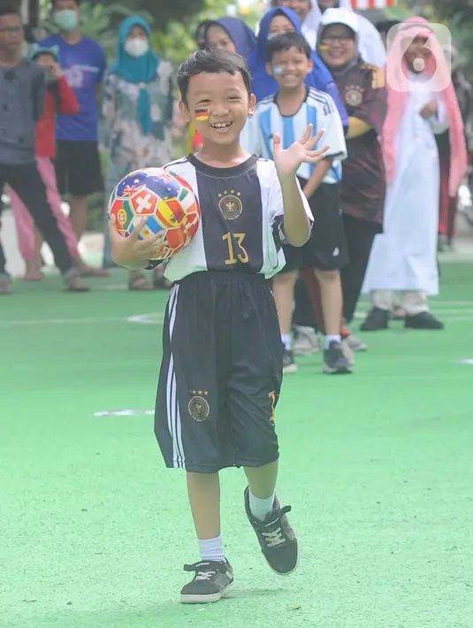 Seorang anak mengenakan jersey atau kostum tim sepak bola peserta Piala Dunia 2022 Qatar menggelar fashion show di Perum Depok Maharaja Blok M1 Cluster Cemara, Rangkapan Jaya, Depok, Minggu (20/11/2022). Fashion show Piala Dunia 2022 diikuti semua kalangan usia dari anak-anak hingga dewasa. (merdeka.com/Arie Basuki)