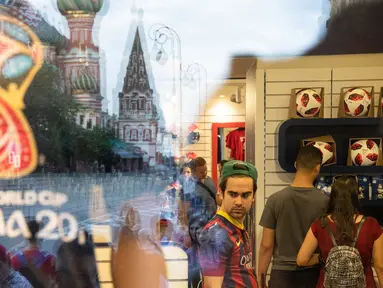 Katedral St. Basil terlihat di cermin saat orang-orang mencari belanjaan di toko resmi Piala Dunia FIFA 2018 di State Shop, GUM, di Moskow, Rusia, (13/7). Kota moskow akan menjadi tuan rumah Final Piala Piala Dunia 2018.  (AP Photo/Pavel Golovkin)