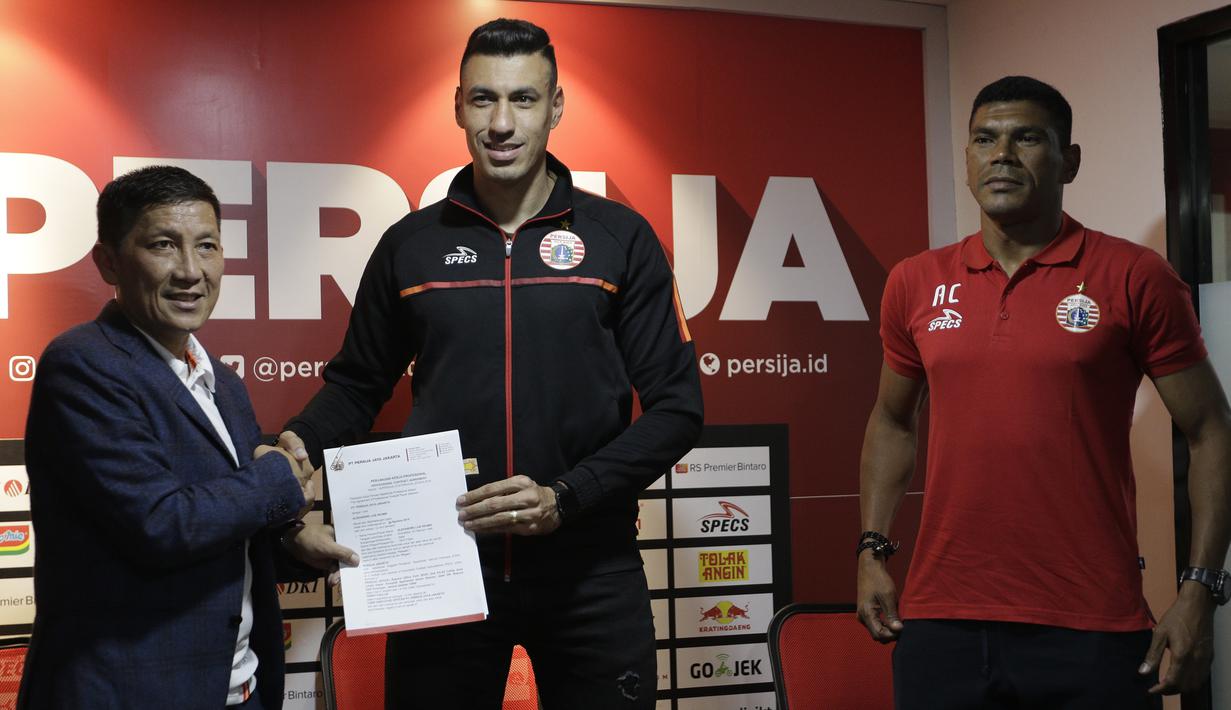 Pemain baru Persija Jakarta, Alexander Luiz Reame, menunjukan kontrak saat konferensi pers perkenalan dirinya di kantor Persija Jakarta, Jakarta, Jumat (30/8). Persija kenalkan pemain asing baru untuk mengarungi putaran 2 Liga 1. (Bola.com/Yoppy Renato)