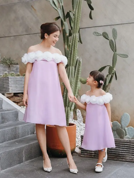 <p>Keduanya tampil feminim dengan dress off shoulder keunguan yang memiliki detail bunga mawar putih di atas dress tersebut.</p>