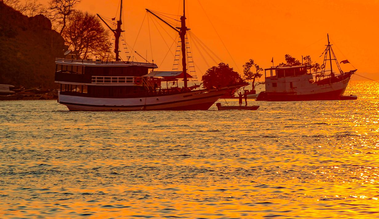 Dengan deretan pulau yang mengelilinginya, pilihan lokasi untuk menyaksikan matahari terbenam sangat beragam. Tampak dalam foto, Sebuah perahu melintas di perairan Labuan Bajo, Flores, Nusa Tenggara Timur sesaat sebelum matahari terbenam. (merdeka.com/Arie Basuki)