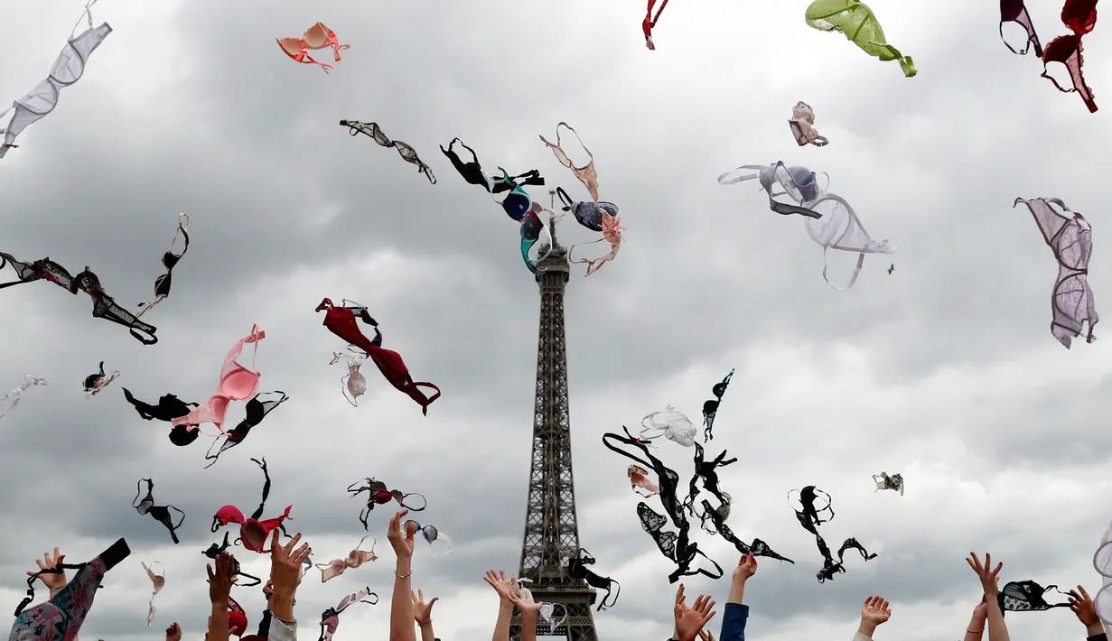 Puluhan wanita melemparkan bra mereka ke udara saat mengikuti acara tahunan "Pink Bra Toss" di depan Menara Eiffel, Paris, Minggu (13/5). Aksi yang diselenggarakan Pink Bazaar ini untuk meningkatkan kesadaran mengenai kanker payudara. (AP/Christophe Ena)