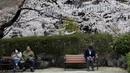 Orang-orang yang memakai masker menikmati melihat bunga sakura yang mekar penuh di Kuil Zojoji, Tokyo, Jepang, Selasa (29/3/2022). (AP Photo/Koji Sasahara)