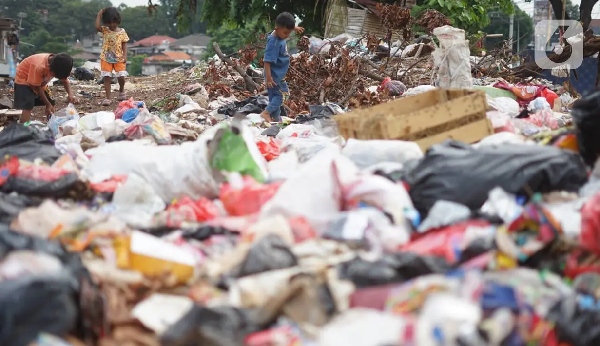 Anak-anak melintasi tumpukan sampah di sekitar Jalan Masjid Al Makmur, Pasar Minggu, Jakarta Selatan, Selasa (10/12/2019). Tumpukan sampah yang tidak hanya berasal dari warga sekitar menimbulkan bau tidak sedap dan dikhawatirkan dapat mengganggu kesehatan. (Liputan6.com/Immanuel Antonius)