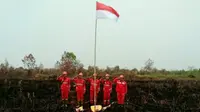 Personel Manggala Agni melaksanakan upacara kemerdekaan Indonesia di tengah lokasi kebakaran lahan. (Liputan6.com/Dok Manggala Agni/M Syukur)