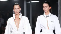 Model Bella Hadid dan Kendall Jenner memakai busana Off White Spring/Summer 2019 selama Paris Fashion Week, Prancis (27/9). Kedua model tersebut tampil cantik membawakan koleksi rancangan Virgil Abloh. (AP Photo/Thibault Camus)