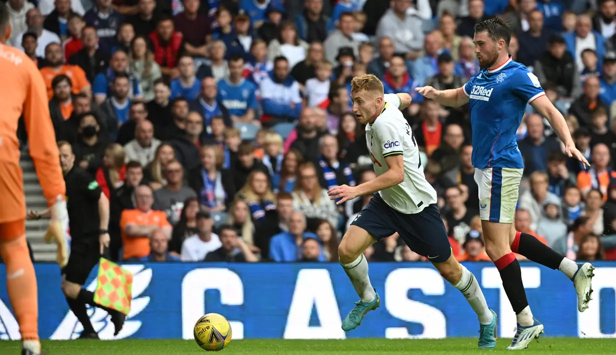 Gelandang Tottenham Hotspur, Dejan Kulusevski (tengah) berlari membawa bola dari kejaran gelandang Rangers, John Souttar selama pertandingan persahabatan di Stadion Ibrox di Glasgow (23/7/2022). Tottenham menang tipis atas Rangers 2-1. (AFP Photo/Andy Buchanan)