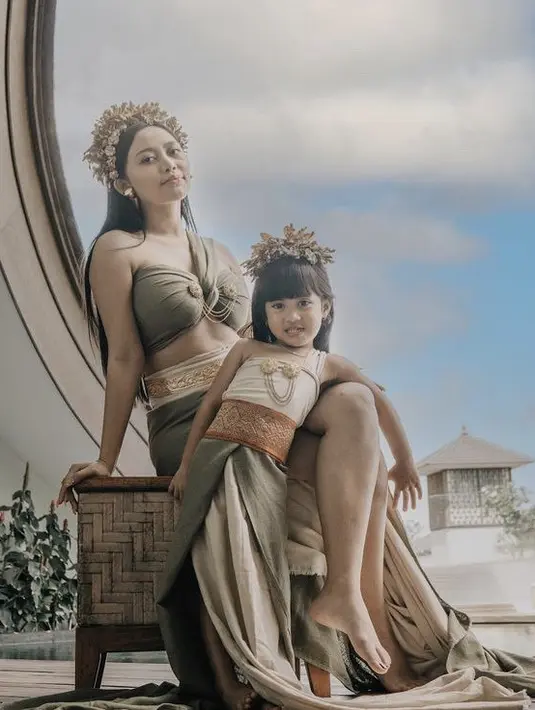 <p>Rachel kompak mengenakan pakaian khas perempuan Bali bersama putrinya, Chava. Chava menggemaskan mengenakan atasan nude dipadu obi dan rok lilit hijaunya. Lengkap dengan aksesori bros dan rambut. (@rachelvennya)</p>