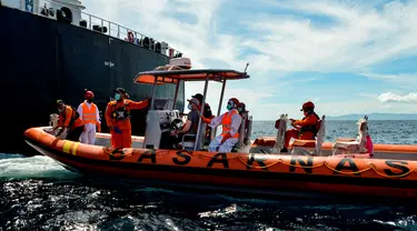 Perahu Basarnas mengevakuasi awak kapal Rusia Alexander Melnik (topi putih) dari kapal tanker Denmark Hulda Maersk di laut lepas pantai Aceh, Selasa (27/4/2021). Alexander Melnik dievakuasi karena mengalami sakit parah di bagian perut bawah sebelah kanan. (CHAIDEER MAHYUDDIN/AFP)