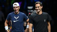 Petenis Swiss&nbsp;Roger Federer (kanan) dan Rafael Nadal dari Spanyol menghadiri sesi latihan menjelang Laver Cup 2022 di O2 Arena, London, Inggris,&nbsp;Kamis, 22 September. (Glyn KIRK / AFP)