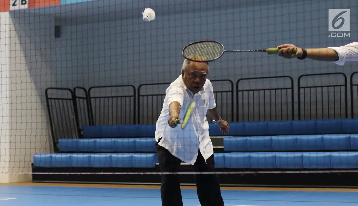 Menteri PUPR, Basuki Hadimuljono mengembalikan kok saat bertanding bulu tangkis disela kunjungannya di Training Facility Gelora Bung Karno Jakarta, Kamis (10/5). Basuki meninjau kesiapan fasilitas dan prasarana Asian Games 2018 (Liputan6.com/Angga Yuniar)