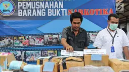 Petugas Badan Narkotika Nasional (BNN) menunjukkan barang bukti narkotika di Lapangan Parkir Gedung BNN, Senin (26/3). Barang bukti tersebut selanjutnya dimusnahkan. (Liputan6.com/Herman Zakharia)