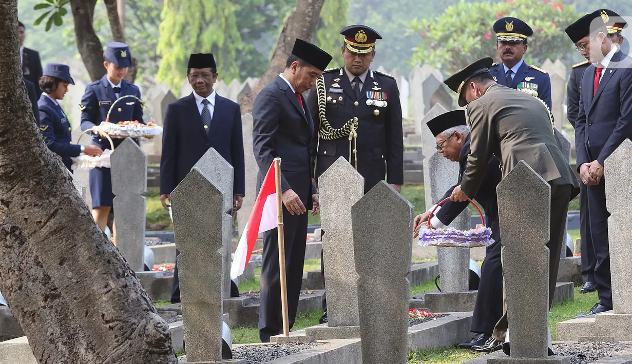 Presiden Joko Widodo bersama Wakil Presiden Ma'ruf Amin melakukan tabur bunga usai upacara peringatan Hari Pahlawan Nasional di TMP Utama Kalibata, Jakarta Selatan, Minggu (10/11/2019). Tabur bunga dilaksanakan sebagai bentuk penghormatan terhadap jasa pahlawan. (Liputan6.com/Herman Zakharia)