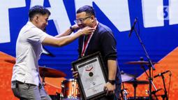 Museum Rekor Indonesia (MURI) memberikan piagam penghargaan atas pencapaian rekor muri pajangan swafoto Polaroid terbanyak oleh pelajar di acara KapanLagi Pensi Bareng Fanta 2025 yang digelar di Gelanggang Olahraga (GOR) atau Gelanggang Mahasiswa Soemantri Brodjonegoro, Jakarta, Sabtu (28/6/2025). (Liputan6.com/Herman Zakharia)
