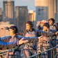 Anggota akademi Tai Chi dan Qigong Australia melakukan latihan Tai Chi di atas Jembatan Sydney Harbour, Australia, Selasa (2/5). Demi keselamatan, mereka dilengkapi tali pengaman yang dikaitkan di pagar besi. (Handout / BRIDGECLIMB SYDNEY / AFP)