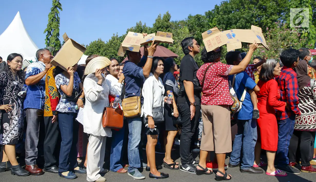 Warga mengantre di kawasan Silang Monas, untuk mengikuti Open House Jokowi di Istana Kepresidenan, Jakarta Rabu (5/6/2019). Meski tempatnya terbatas, Presiden Jokowi menggelar Open House yang dibagi dua sesi bagi pejabat negara dan masyarakat. (Liputan6.com/HO/Grandy)