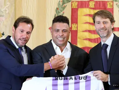 Legenda sepak bola Brasil Ronaldo (tengah), walikota Valladolid Oscar Puente (kiri) dan presiden Real Valladolid Carlos Suarez berpose dengan Jersey klub Real Valladolid saat konferensi pers di Valladolid, Spanyol, (3/9). (AFP Photo/Cesar Manso)