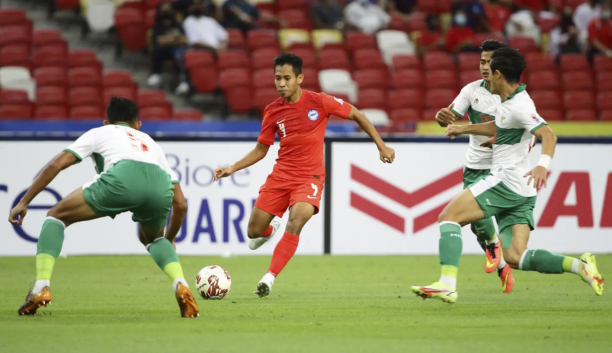Pemain Singapura Nazrul Nazari (tengah) menggiring bola melewati para pemain Indonesia pada pertandingan leg pertama semifinal Piala AFF 2020 di National Stadium, Singapura, Rabu (22/12/2021). Pertandingan berakhir imbang 1-1. (AP Photo/Suhaimi Abdullah)