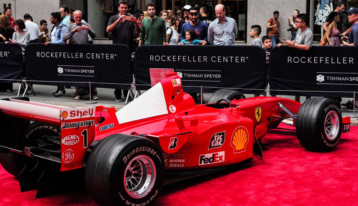 Pengunjung melihat mobil mantan pembalap Ferrari F1 dari Jerman, Michael Schumacher saat dipamerkan di perayaan ulang tahun Ferrari ke-70 di Rockefeller Plaza, New York, AS (8/10). (AFP Photo/Jewel Samad)