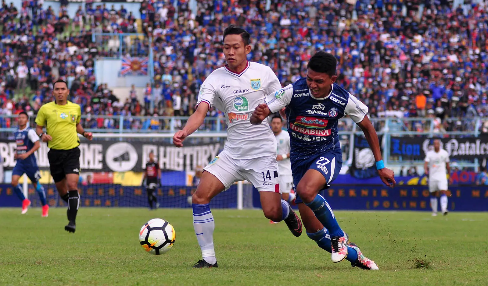 Striker Arema, Dedik Setiawan (biru), saat melewati pemain Persela, Birul Walidain, di Stadion Kanjuruhan, Malang, Sabtu (7/7/2018). (Bola.com/Iwan Setiawan)
