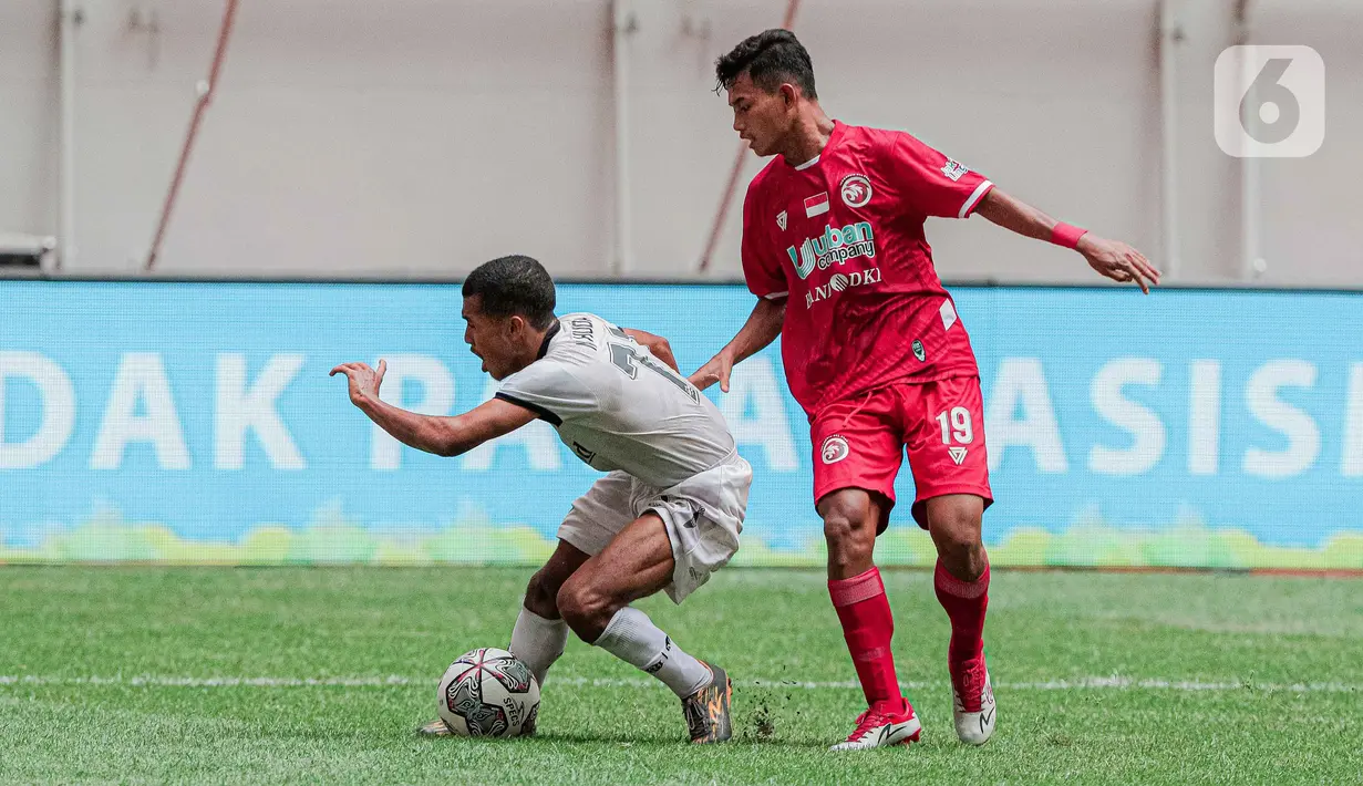 Gelandang Bali United U-18, Nur Huda mengontrol bola dari kawalan gelandang Indonesia All Stars U-20, Nugroho Santoso pada pertandingan IYC 2021 di Jakarta International Stadium, Jakarta, Selasa (19/4/2022). Indonesia All Stars U-20 menang atas  Bali United U-18 2-1. (Liputan6.com/Faizal Fanani)
