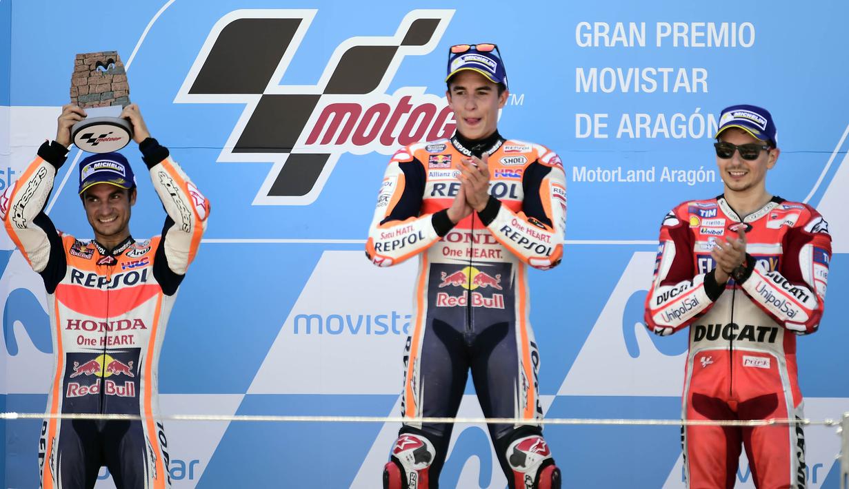 Pebalap Repsol Honda, Marc Marquez dan Dani Pedrosa bersama pebalap Ducati, Jorge Lorenzo, naik podium GP Aragon di Sirkuit Motorland, Alcaniz, Minggu (24/9/2017). Marquez berhasil finis tercepat dengan waktu 42 menit 6,819 detik. (AFP/Jose Jordan)