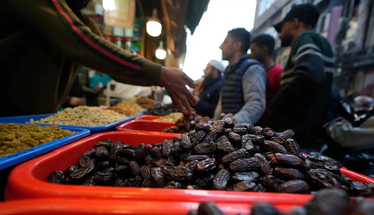 Umat Muslim Kashmir berbelanja untuk kebutuhan bulan suci Ramadan di sebuah pasar di Srinagar, Rabu 18 Februari 2026. Kurma merupakan buah favorit dan harus ada saat bulan suci Ramadan. (AP Photo/Mukhtar Khan)