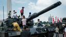 Warga yang berkunjung ke Monumen Nasional (Monas) di Jakarta terlihat antusias menyaksikan sekaligus menaiki sejumlah alutsista TNI yang dipamerkan. (YASUYOSHI CHIBA/AFP)