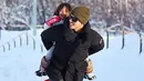 Pemain Consadole Sapporo, Irfan Bachdim menggendong putrinya saat bermain salju di Jepang. (Instagram)