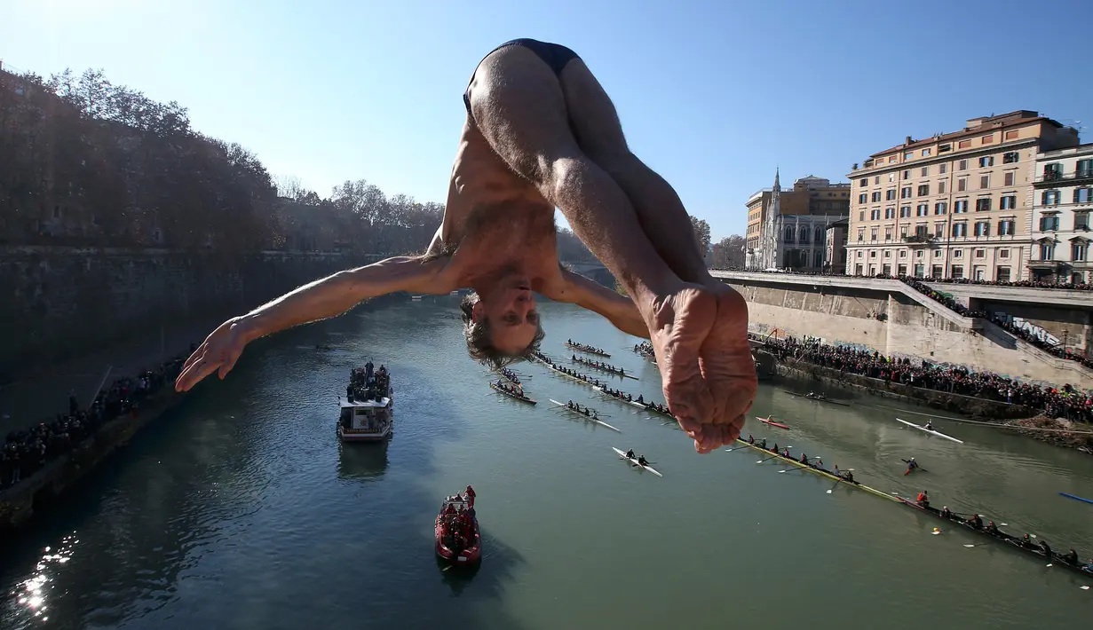 Seorang pria Italia bernama, Marco Fois melompat ke Sungai Tiber dari jembatan Cavour, Roma, Italia (1/1). Tradisi ini dimulai kembali pada tahun 1946 hingga sekarang. (Reuters/Alessandro Bianchi)