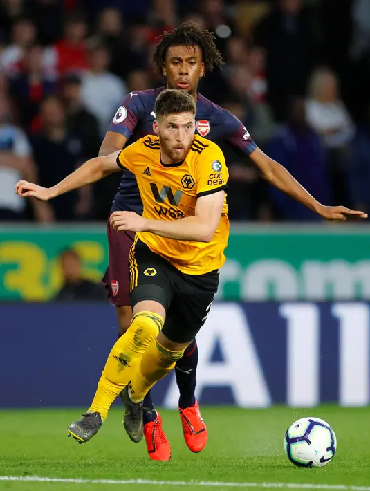 Pemain Wolverhampton Wanderers, Matt Doherty berebut bola dengan gelandang Arsenal, Alex Iwobi pada laga lanjutan Liga Inggris 2018-2019 di Stadion Molineux, Rabu (24/4). Arsenal harus tumbang dengan skor 1-3 kala bertandang ke markas Wolverhampton Wanderers. (REUTERS/Eddie Keogh)