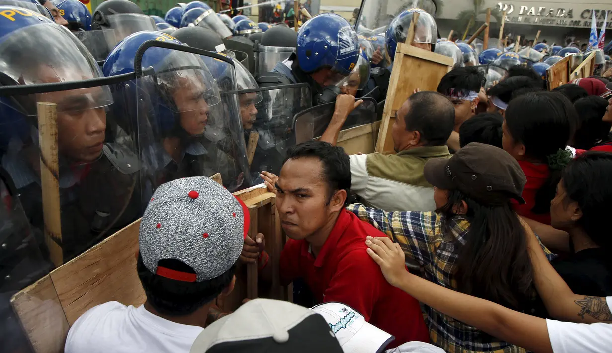Demonstran terlibat aksi saling dorong dengan polisi saat berusaha mendekati lokasi pertemuan Asia-Pacific Economic Cooperation (APEC) di Manila, Filipina, Kamis (19/11). (REUTERS/Edgar Su)