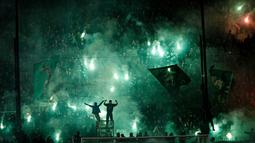 Suporter Panathinaikos menyalakan suar setelah pertandingan antara Panathinaikos melawan Olympiakos dalam Liga Super Yunani di Stadion Apostolos Nikolaides, Athena, dibatalkan. (21/11/2015). (AFP/SOOC/Alexandros Michailidis)