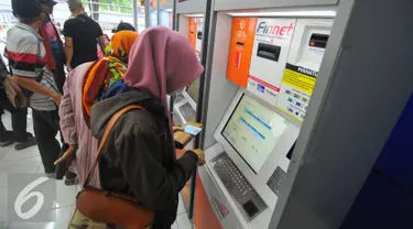 Calon penumpang membeli tiket di mesin penjual tiket kereta api otomatis di Stasiun Senen, Jakarta, Selasa (20/12). Jelang libur Natal dan tahun baru tiket Kereta Api sudah habis untuk keberangkatan Jateng dan Jatim. (Liputan6.com/Angga Yuniar)