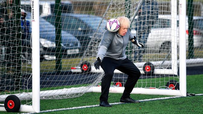Perdana Menteri Inggris Boris Johnson menjadi kiper sebelum pertandingan sepak bola putri junior antara Hazel Grove United JFC dan Poynton di Cheadle Hulme, Inggris, Sabtu (7/12/2019). Aksi itu dalam rangka kampanye jelang pemilu Inggris pada 12 Desember 2019. (Toby Melville/Pool Photo via AP)