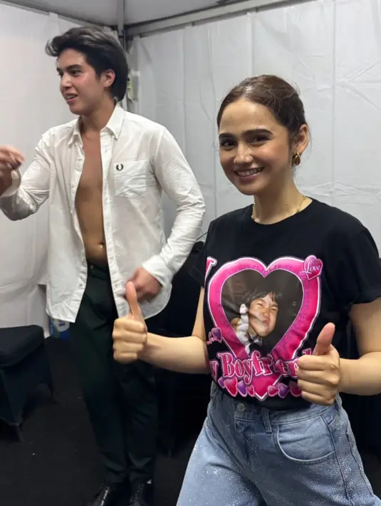 Menyaksikan kekasihnya bersama The Changcuters, Syifa pun mode bucin. Ia mengenakan kaos hitam dengan gambar tulisan foto I Love My Boyfriend dengan foto masa kecil El Rumi. [@rklopperrr]