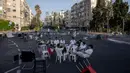 Sejumlah pemuda duduk bersama di persimpangan jalan bebas kendaraan saat perayaan Hari Raya Yom Kippur di Ramat Gan, Israel, Senin (25/9/2023). Banyak warga yang menggunakan sepeda ke jalan karena tidak ada lalu lintas yang diizinkan di jalan tersebut. (AP Photo/Oded Balilty)