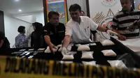 Petugas Dir Narkoba Bareskrim Polri juga menyita sepuluh handphone, tiga buku tabungan dan beberapa kartu identitas milik tersangka di Gedung BNN, Jakarta, Selasa (21/4/2015). (Liputan6.com/Johan Tallo)