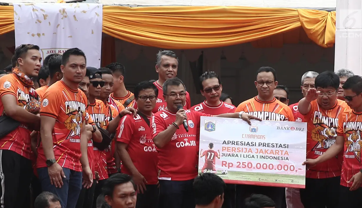 Gubernur DKI Jakarta Anies Baswedan menyaksikan penyerahan apresiasi prestasi dari Dirut Bank DKI Wahyu Widodo kepada Dirut Persija Jakarta Gede Widiade saat penyerahan piala Liga I di Balai Kota, Jakarta, Sabtu (15/12). (Liputan6.com/Herman Zakharia)