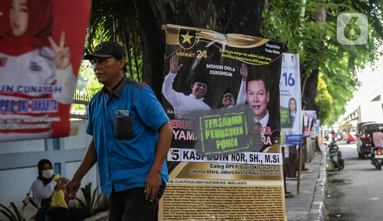 Poster dari para Calon Legislatif (caleg) Pemilu 2024 dilabeli tulisan "Tersangka Penusukan Pohon" terpaku dipohon yang tertanam di kawasan Jakarta Utara, Jumat (12/1/2024). (Liputan6.com/Angga Yuniar)