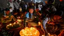 Sejumlah warga menyalakan lilin sebelum melepaskan lampion buatan tradisional ke langit selama festival tahunan Tazaungdaing di Taunggyi, Myanmar (19/11). (REUTERS/Soe Zeya Tun)