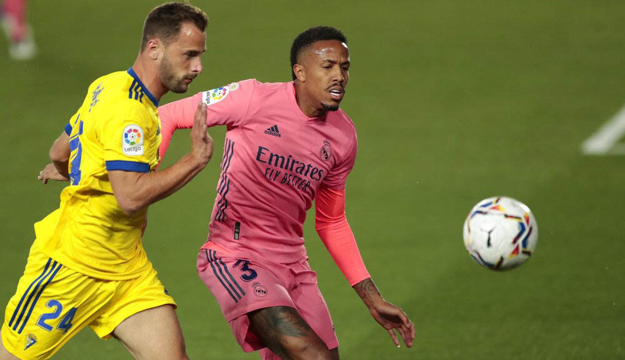 Pemain Real Madrid, Eder Militao, berebut bola dengan pemain Cadiz, Filip Malbasic, pada laga Liga Spanyol di Stadion Alfredo Di Stefano, Minggu (18/10/2020). Real Madrid takluk dengan skor 1-0. (AP/Bernat Armangue))