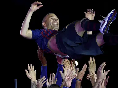 Gelandang Barcelona, Andres Iniesta, diangkat rekan-rekannya usai melawan Real Sociedad pada laga La Liga Spanyol di Stadion Camp Nou, Barcelona, Minggu (20/5/2018). Dirinya berpisah dengan klub yang 22 tahun telah dibela. (AFP/Lluis Gene)
