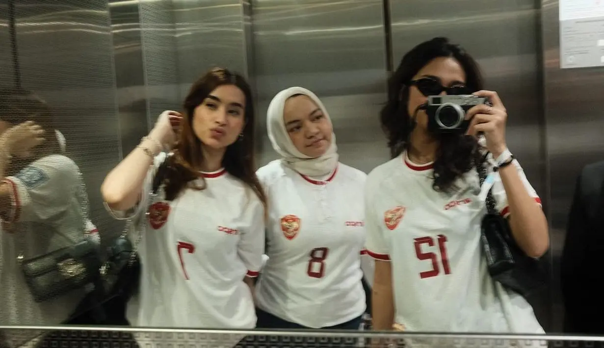 Rismahani, istri Witan Sulaeman tampil dengan padu padan jersey timnas warna putihnya, hijab putih, dan celana jeans. [@acadumpie]