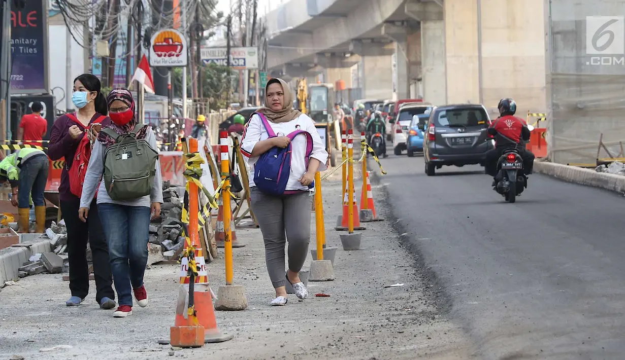 Pejalan kaki melintasi Jalan Panglima Polim Raya yang mengalami penyempitan di Jakarta, Rabu (8/8). Penyempitan jalan terjadi karena adanya proyek MRT dan perbaikan jalan. (Liputan6.com/Immanuel Antonius)