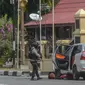 Petugas kepolisian mengamankan mobil yang digunakan terduga teroris setelah serangan di luar markas polisi di Pekanbaru, Riau (16/5). Empat pelaku penyerangan ditembak dan tewas ketika mereka melakukan serangan.  (AFP Photo/Dedy Sutisna)